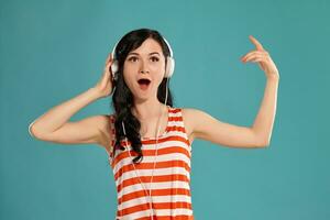 Studio photo of a gorgeous girl teenager posing over a blue background.