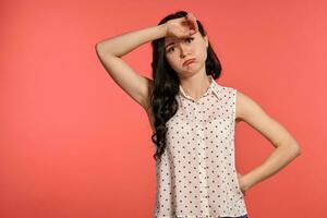 estudio Disparo de un encantador niña adolescente posando terminado un rosado antecedentes. foto