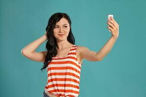 Studio photo of a gorgeous girl teenager posing over a blue background.