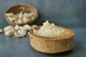 close up of minced garlic on a wooden spoon photo