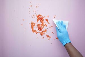 hand in blue rubber gloves cleaning table with cloth photo