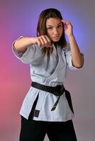 Athletic woman in traditional kimono is practicing karate in studio. photo