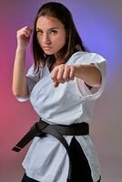 atlético mujer en tradicional kimono es practicando kárate en estudio. foto