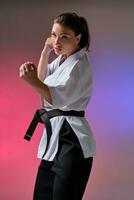 Athletic woman in traditional kimono is practicing karate in studio. photo