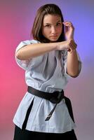 Athletic woman in traditional kimono is practicing karate in studio. photo