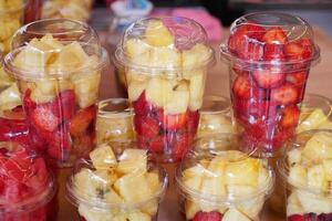 piña, kiwi y fresas en. el plastico envase de venta a tienda foto