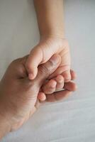 father holding hand of baby child, photo