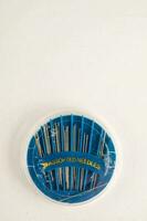 a blue plastic container with a bunch of needles photo