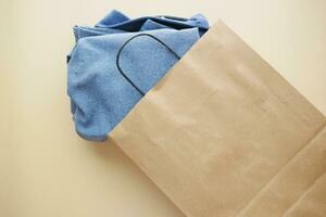 top view of craft paper bag with shirt , photo