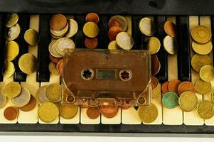 a cassette player and coins on a piano keyboard photo