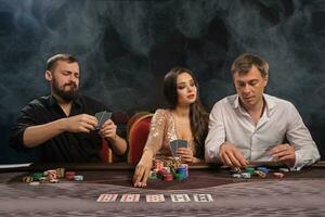 Group of a young rich friends are playing poker in casino. photo