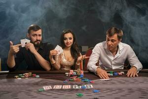 Group of a young rich friends are playing poker in casino. photo