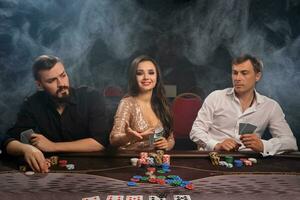 Group of a young rich friends are playing poker in casino. photo