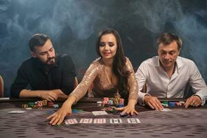 Group of a young rich friends are playing poker in casino. photo