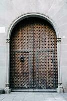 un medieval cerrado puerta con hierro guarniciones en un Roca pared. típico arquitectura de Europa. foto