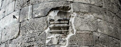 Close up old gray brick textured wall concept photo. Mediterranean architecture, urban city life. photo