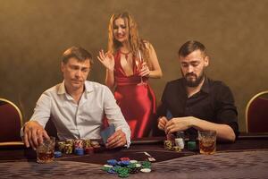 Group of a young wealthy friends are playing poker at a casino. photo