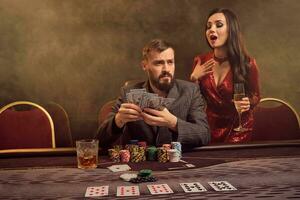 Charming wealthy couple are playing poker at a casino. photo