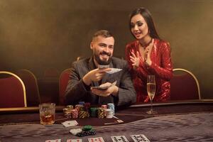 Charming wealthy couple are playing poker at a casino. photo