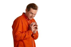 Close-up portrait of a ginger guy in orange shirt posing isolated on white background. Sincere emotions. photo