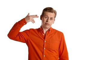 Close-up portrait of a ginger guy in orange shirt posing isolated on white background. Sincere emotions. photo