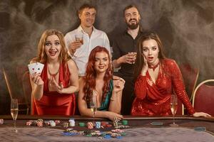 Group of a young wealthy friends are playing poker at a casino. photo