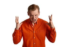 Close-up portrait of a ginger guy in orange shirt posing isolated on white background. Sincere emotions. photo