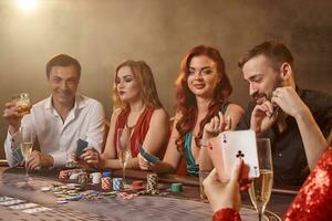 grupo de un joven rico amigos son jugando póker a un casino. foto