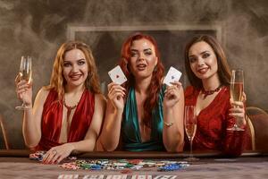 Group of a young wealthy ladies are playing poker at a casino. photo