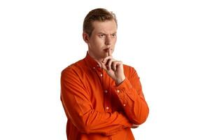 Close-up portrait of a ginger guy in orange shirt posing isolated on white background. Sincere emotions. photo