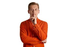 Close-up portrait of a ginger guy in orange shirt posing isolated on white background. Sincere emotions. photo