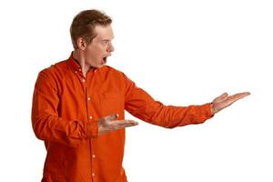 Close-up portrait of a ginger guy in orange shirt posing isolated on white background. Sincere emotions. photo