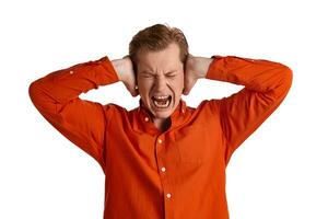 Close-up portrait of a ginger guy in orange shirt posing isolated on white background. Sincere emotions. photo