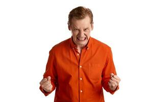 Close-up portrait of a ginger guy in orange shirt posing isolated on white background. Sincere emotions. photo