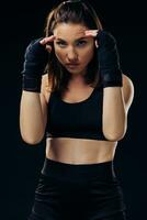 Athletic woman in boxing mittens is practicing karate in studio. photo