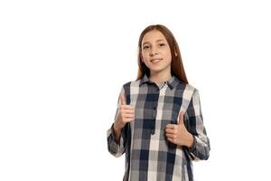 Beautiful teenage girl in a casual checkered shirt is posing isolated on white studio background. photo