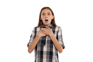 Beautiful teenage girl in a casual checkered shirt is posing isolated on white studio background. photo