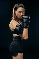 atlético mujer en boxeo guantes es practicando kárate en estudio. foto