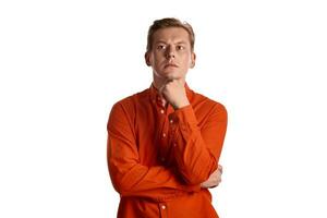 Close-up portrait of a ginger guy in orange shirt posing isolated on white background. Sincere emotions. photo