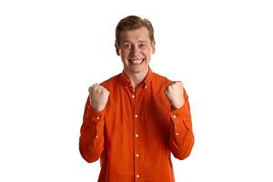 de cerca retrato de un jengibre chico en naranja camisa posando aislado en blanco antecedentes. sincero emociones foto