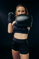 Athletic woman in boxing gloves is practicing karate in studio. photo