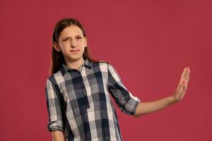 hermosa Adolescente niña en un casual a cuadros camisa es posando en contra un rosado estudio antecedentes. foto