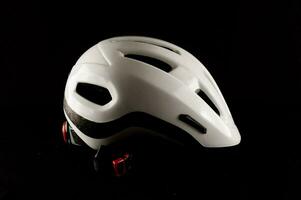 un blanco bicicleta casco en un negro antecedentes foto