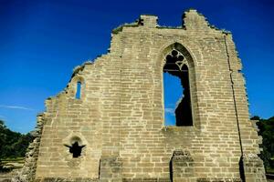 the ruins of a stone building with a blue sky photo