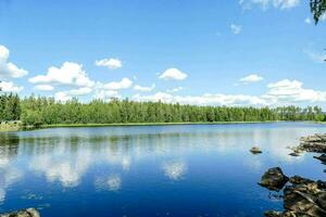 un lago rodeado por arboles y rocas foto