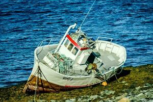 a boat is sitting on the rocky shore photo