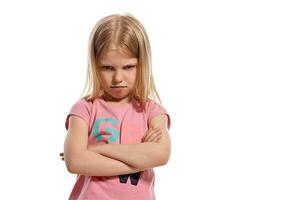 Close-up portrait of a nice blonde little kid in a pink t-shirt posing isolated on white background. photo