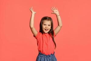 Close-up studio shot of beautiful brunette little girl posing against a blue background. photo