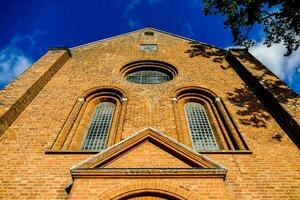 the front of a brick church against a blue sky photo