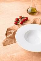 Color of the year 2024, Peach Fuzz. empty plate for serving pasta or soup, on blue background photo
